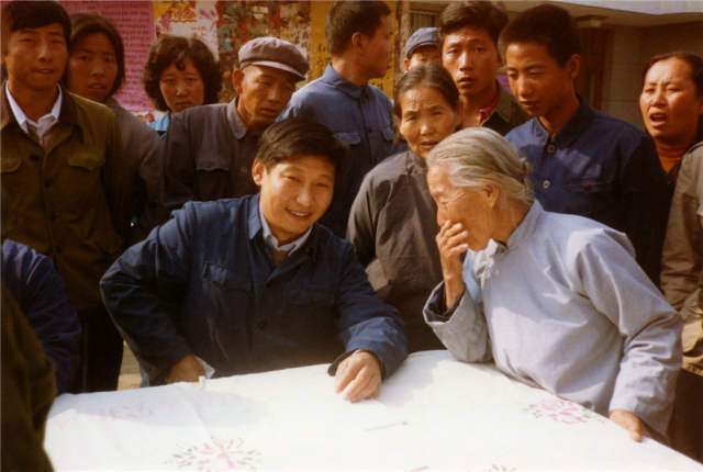 1983年，时任河北正定县委书记的习近平（前排居中），临时在大街上摆桌子听取老百姓意见。新华社发